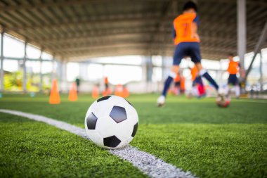 Yeşil suni sahada futbol, bulanık futbol takımı eğitimi. Kalenin önündeki beyaz virajdaki top..