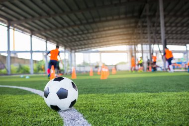 Yeşil suni sahada futbol, bulanık futbol takımı eğitimi. Kalenin önündeki beyaz virajdaki top..