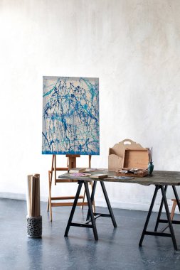 Sanatçının çalışma alanı, insan yok. Easel, resim öğretmek için tuvaller ve fırçalar. İskandinav iç mimarisi, çatı katı. Sanatçının, atölyenin, hobilerin stüdyosunun içinde. Stüdyo çizimleri, kalemler.