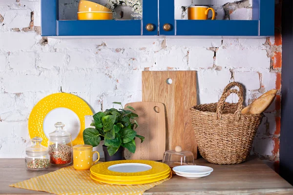 Kitchen utensils, concept of home decor kitchen. Modern kitchen with cooking utensils and clean dishware. Kitchen tools, cutting boards on table against white brick wall. dinning interior. rustic