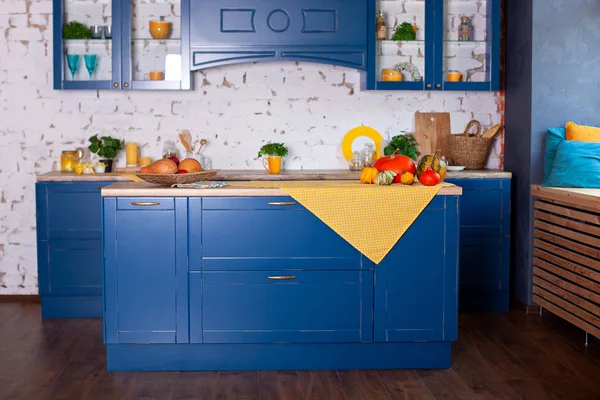 Modern Blue kitchen interior in loft style with furniture. Stylish Scandinavian cuisine in decor. wooden kitchen in rustic style. Empty wooden table and yellow spring decor in kitchen interior.