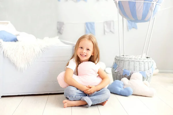 カジュアルな服の少女は 装飾的な風船の背景に雲の枕を保持しています 子供は子供部屋で遊ぶ 子供の頃 旅行の概念 誕生日や祝日の飾り — ストック写真