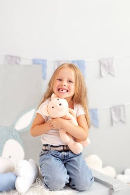 Mutlu gülümseyen dişsiz küçük sarışın kız. Çocuk odasında süt dişleriyle gülümseyen bir çocuk. Küçük tatlı kızıl kız evde oyuncak ayıya sarılıyor. Çocuk anaokulunda bir oyuncakla oynuyor.