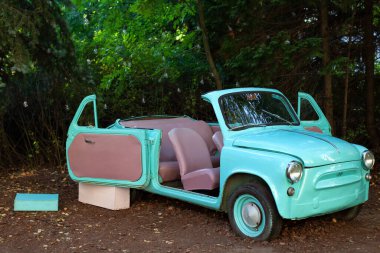 Arka planda yanan çelenk ampulleri üzerinde yazın bahçede duran eski model küçük bir araba. Düğün dekorasyonu. Tatil için bahçe ve ev dekorasyonu. Yaz gezisi, seyahat.