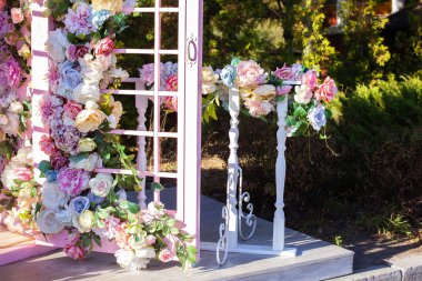Tahta kemer ve çiçek süslemeleriyle yaz bahçesinde düğün için güzel romantik bir yer. Çardak renkli çiçeklerle süslenmiş. Baş bohem ahşaptır. Çiçek.. 