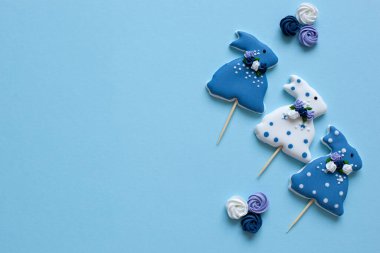 Paskalya - beyaz arka planda jöleli tavşan şekilli kurabiyeler. Pastel renkli Paskalya kurabiyeleriyle mutlu paskalya arkaplanları. Tavşanlar ve çiçekler. Bahar çiçekleri ve Paskalya zencefilli ekmekleri masada.