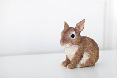 Beyaz arka planda izole edilmiş seramik tavşan figürü. Paskalya tavşanının kahverengi heykelinin yakın çekimi. Porselen tavşan. Beyaz arka planda Paskalya dekorasyonu seramik paskalya tavşanı. kopyalama alanı. metin