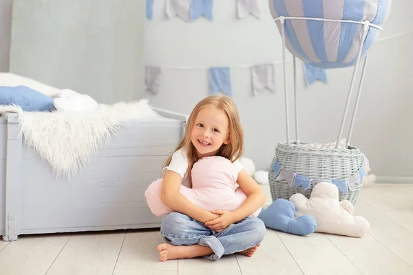 カジュアルな服の少女は 装飾的な風船の背景に雲の枕を保持しています 子供は子供部屋で遊ぶ 子供の頃 旅行の概念 誕生日や祝日の飾り — ストック写真