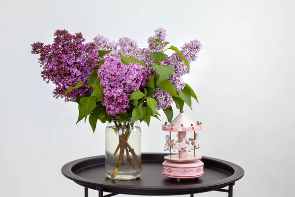 뮤지컬 카풀과 테이블에 아름다운 라일락 꽃들이 배경을 이루고 곁들인 장난감 — 스톡 사진