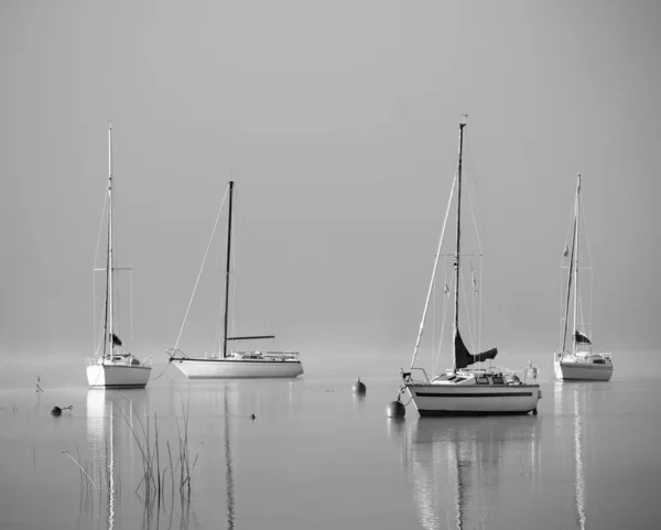 Foggy lake with lonely boats - Mondsee, Austria