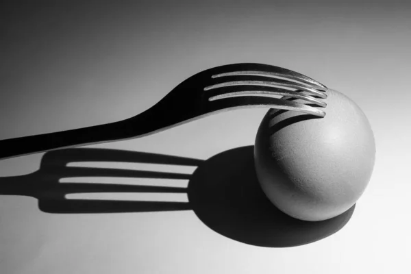 Forchetta e uova e la loro ombra, primo piano su sfondo bianco — Foto Stock