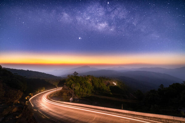 Milky Way Galaxy with lighting on the road and layer of mountain at Doi inthanon Chiang mai, Thailand