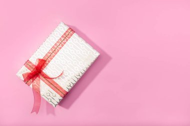 Pembe arka planda izole edilmiş bir hediye kutusu. Üst görünüm, alanı kopyala