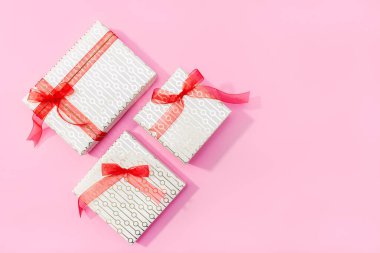 Mevcut arkaplan. Pembe arka planda hediyeler. Düz konum, üst görünüm, kopyalama alanı