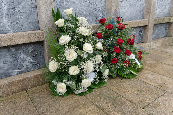 букет красочных цветов во время празднования Дня всех святых христиан, лежащих в гробнице на кладбище