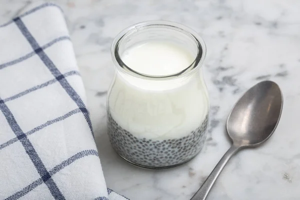 Greek yogurt chia pudding in glass on marble table