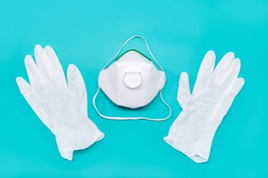 Safety mask FFP2 and protective gloves isolated on green background