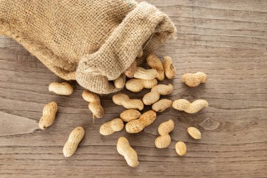 Çuval bezi ve fıstık kırsal ahşap masada. Arachis hipogaea