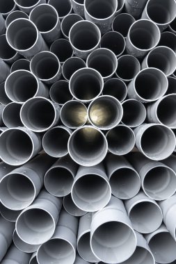 Gri PVC tüpleri, nur saçan, sıralara dizilmiş plastik borular.