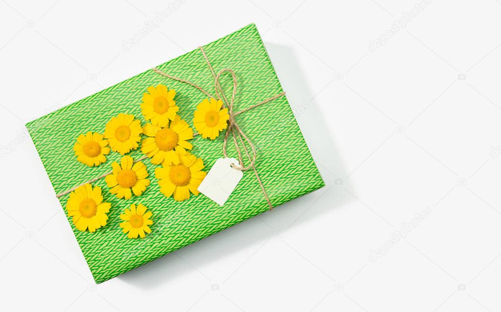 Gift or present box with blank label and daisy flowers on white background. Copy space Top view. Mock up