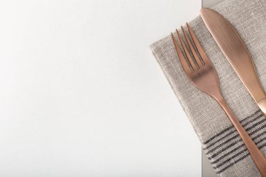 Menü arka planı. Bakır çatal ve bıçak geri dönüşümlü kağıtta. Boşluğu kopyala