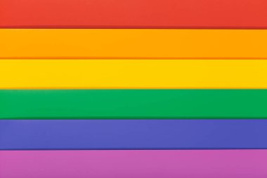 Gökkuşağı bayrağı arka planı, genellikle gay gurur bayrağı ya da LGBTQ gurur bayrağı olarak bilinir. Renkli bir karton grubunun fotoğrafı