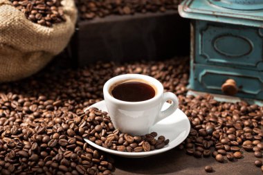 Bir fincan espresso kahve, kızarmış fasulye ve eski öğütücü. Rustik Kahve arka planı