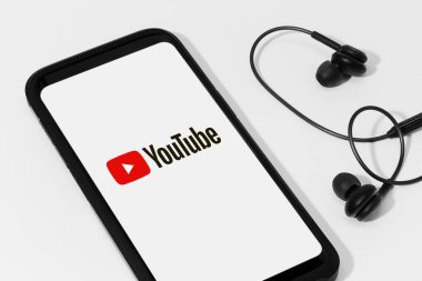 Galiçya, İspanya; 11 Mayıs 2020: Kulaklıklar ve akıllı telefonlar Youtube logosunu ekranda gösteriyor