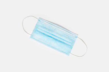 Tıbbi koruyucu yüz maskesi beyaz arka planda izole edilmiş. Coronavirus COVID-19 koruma konsepti. Uzayı kopyala Üst görünüm