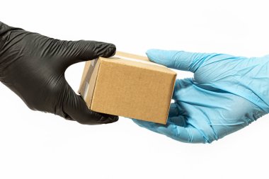 Kurye, bir müşteriye ya da internet alıcısına paket teslim etmek için koruyucu eldiven teslim ediyor. Coronavirus COVID-19 salgını sırasında eve teslim