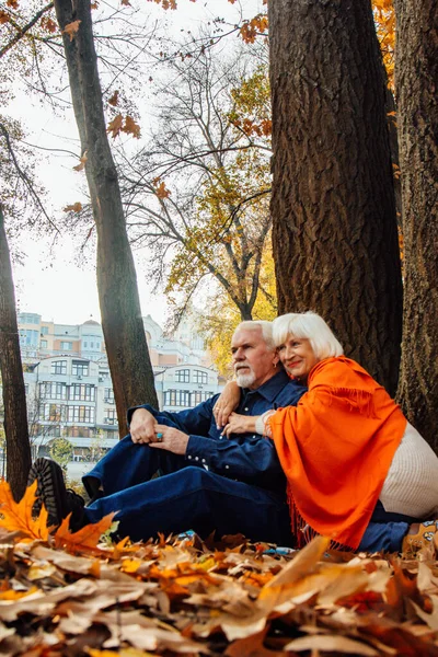 Nahaufnahme Porträt einer glücklichen alten Frau und eines Mannes in einem Park im herbstlichen Laub. — Stockfoto