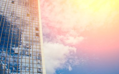 Güzel mavi gökyüzüne karşı bir sürü penceresi olan bir gökdelen. İş ve mali konsept.