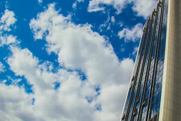 Un rascacielos con muchas ventanas contra un hermoso cielo azul. Concepto empresarial y financiero . — Foto de Stock