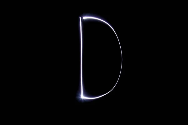 Alphabet made of neon light on a black background. Isolated top view, letter d. — Stock Photo, Image