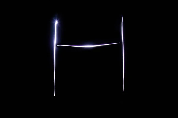 Abeceda vyrobená z neonového světla na černém pozadí. Izolovaný pohled shora, písmeno h. — Stock fotografie