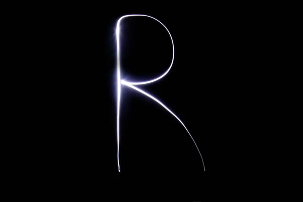 Алфавит из неонового света на черном фоне. Изолированный вид сверху, буква r . — стоковое фото
