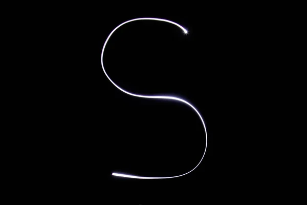 Siyah zemin üzerinde neon ışıktan yapılmış alfabe. İzole edilmiş üst görünüm, harf s. — Stok fotoğraf