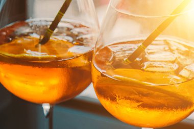 Bardakta buz küpleri ve çevre dostu karton tüplü Aperol alkollü içecek. Popüler kokteyl, bar menüsü, portakal suyu..