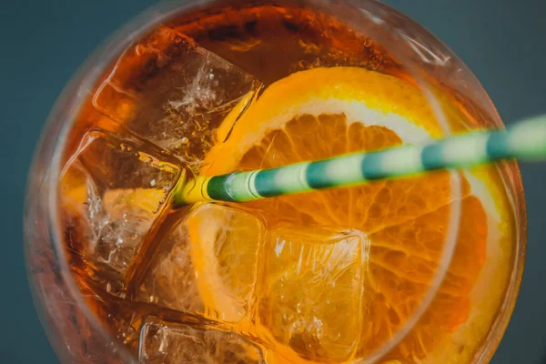 Boisson alcoolisée Aperol avec glaçons dans un verre et un tube en carton écologique. Cocktail populaire, menu de bar, liquide orange . — Photo