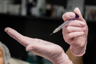 kontur plastik. Bir Kozmetolog sıkın ve bir kadın yüzü cilt kırışıklıkları pürüzsüz bir botulinum toksin enjekte.