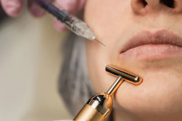 Z tworzywa sztucznego. Kosmetolog wstrzykuje toksyny botulinowej, aby dokręcić i wygładzić zmarszczki na skórze kobiecej twarzy. — Zdjęcie stockowe