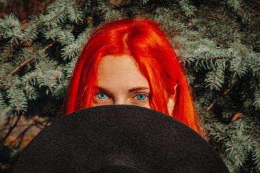 Uzun saçlı, seksi, kızıl saçlı kız. Sarı yapraklı arka planda mükemmel bir kadın portresi. Muhteşem saçlar ve koyu mavi gözler. Doğal güzellik, temiz ten, yüz ve saç bakımı.