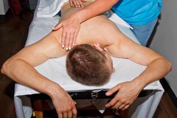 Wellness koncept. Profesionální masér dává muži thajskou masáž bambusovými tyčinkami v lázních. Relaxace a zotavení po práci. — Stock fotografie