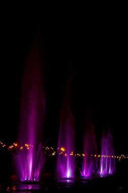 Ukrayna. Kyiv - 05.06.2019 Gökkuşağı renginin gece ışıklarıyla gölde dans eden fıskiyeler.