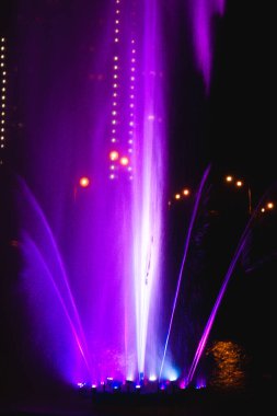 Ukrayna. Kyiv - 05.06.2019 Gökkuşağı renginin gece ışıklarıyla gölde dans eden fıskiyeler.