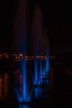 Ukrayna. Kyiv - 05.06.2019 Gökkuşağı renginin gece ışıklarıyla gölde dans eden fıskiyeler.