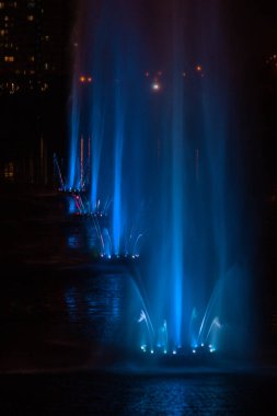 Ukrayna. Kyiv - 05.06.2019 Gökkuşağı renginin gece ışıklarıyla gölde dans eden fıskiyeler.