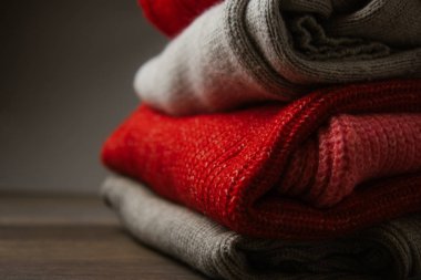 Renkli örgü süveter deseni yakın plan. El yapımı merino yünü ürünü. Bir yığın çiçekli katlanmış kıyafet..