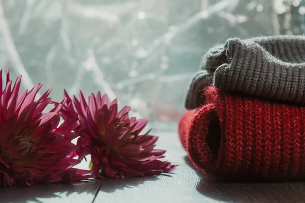 Patroon van kleurrijke gebreide truien close-up. Handgemaakte merino wol product. Een stapel gevouwen kleren met bloemen. — Stockfoto