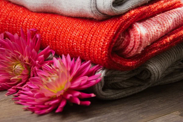 Patroon van kleurrijke gebreide truien close-up. Handgemaakte merino wol product. Een stapel gevouwen kleren met bloemen. — Stockfoto